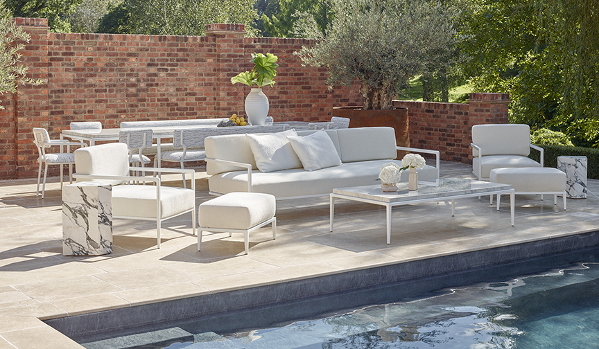 Luxury outdoor furniture collection of white chairs sofas chaise loungers and tables.